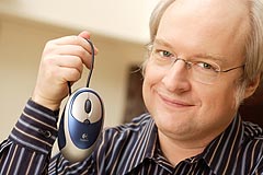 Photograph of Jakob Nielsen holding a mouse.