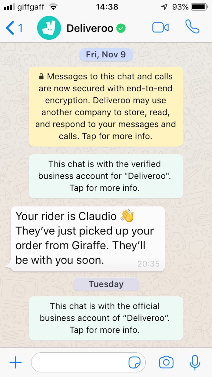 A user receives a message in WhatsApp from Deliveroo, which says "Your rider is Claudio. They've just picked up your order from Giraffe. They'll be with you soon."