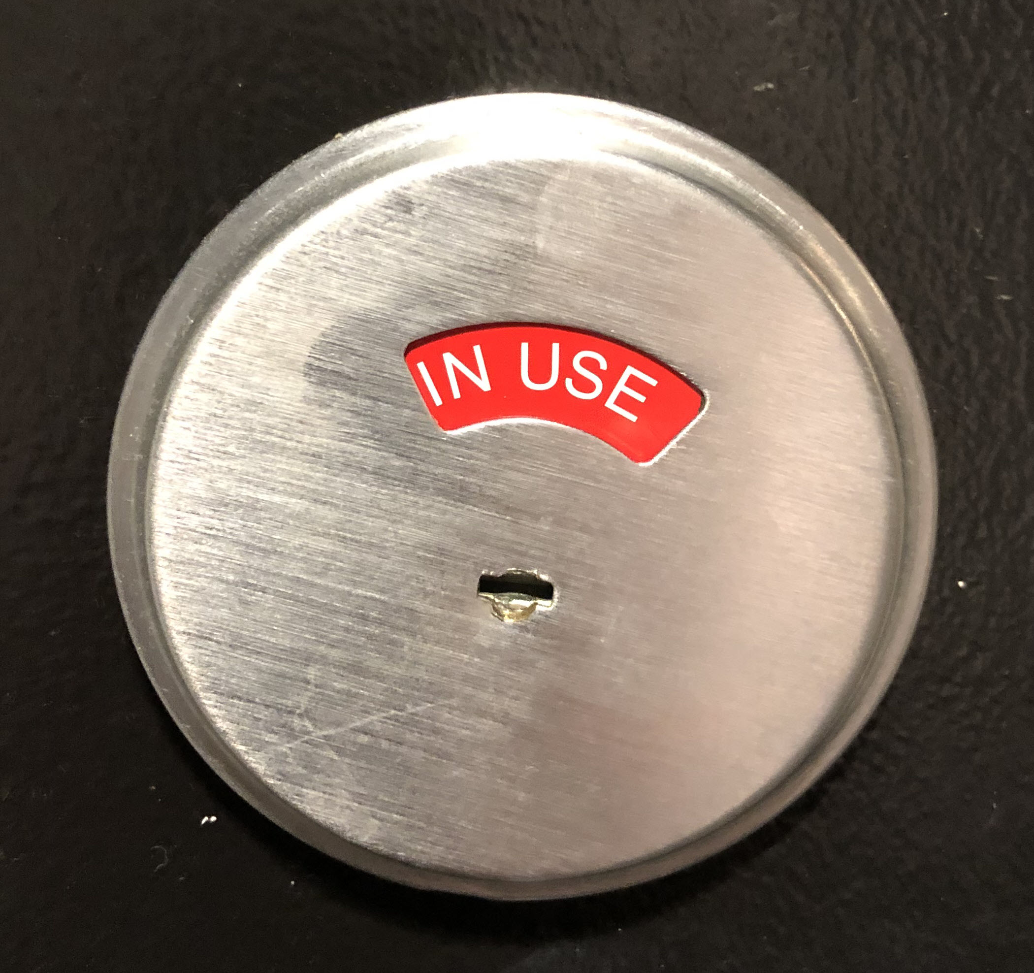 the words "in use" on  red background in a metal door lock