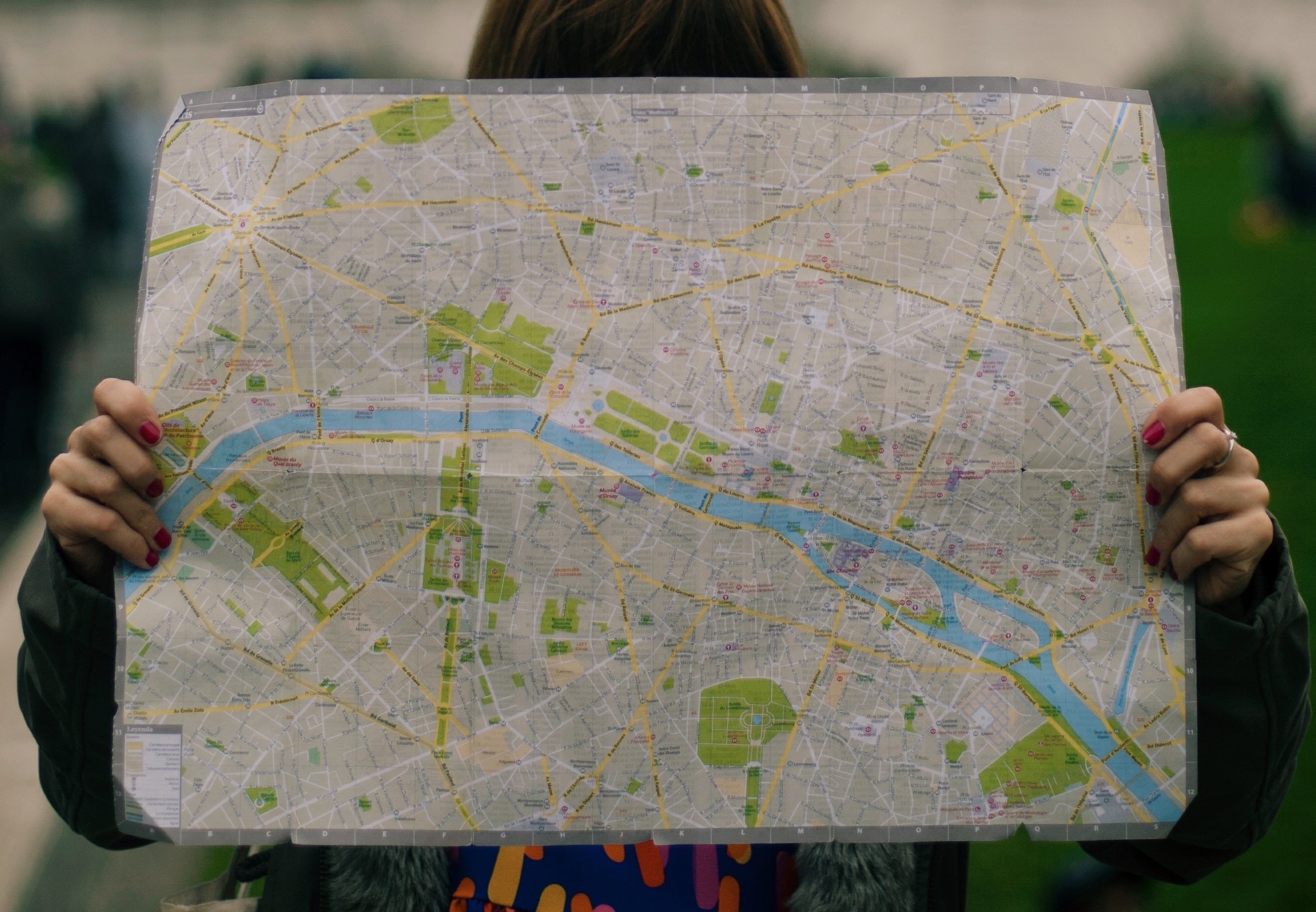 A person holding a paper map of Paris