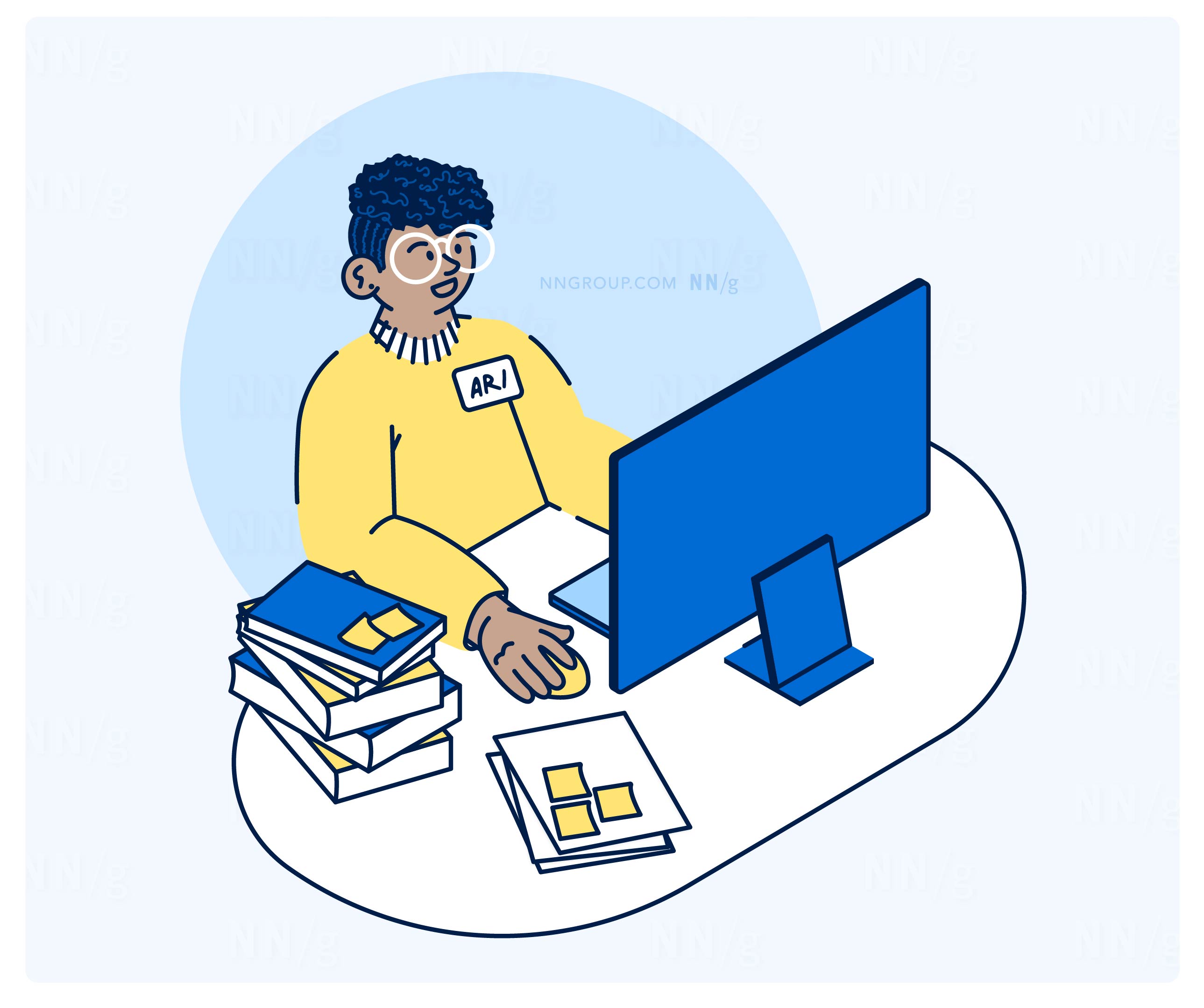 A person with short, curly hair and glasses works at a computer. They wear a yellow sweater with a name tag labeled “Ari.” Several books and papers with sticky notes are on the desk.